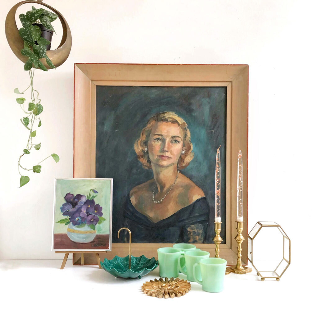 This vignette contains a portrait painting, jadeite cups, a mini flower painting and candlesticks.