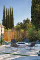 firepit with black chairs in backyard patio of renovated Eichler home