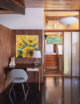 wood paneling in wall of MCM house with desk area and yellow floral painting