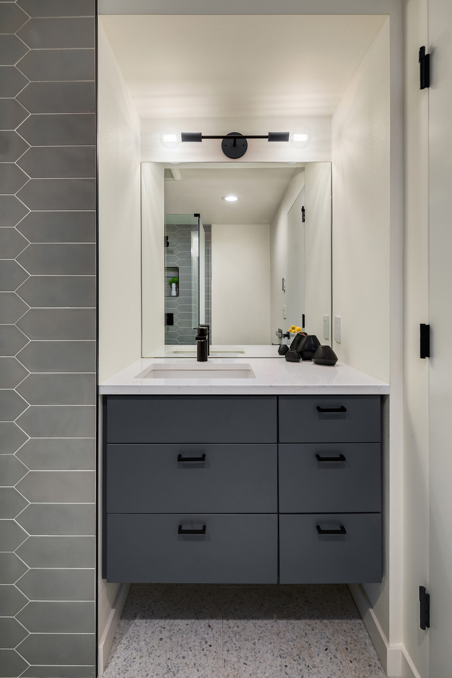 modern updated bathroom with gray tile and cabinetry