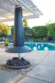 outdoor fireplace and pool with landscaping along the perimeter in Rossmoor MCM home