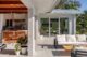 A covered patio with cozy seating and breezeway with dining and bar area for hosting.