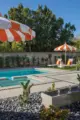 pool with orange and white shade umbrellas in backyard of 1957 ranch in Woodland, CA