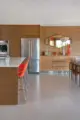 orange barstools and Blenko glass collection add color in otherwise neutral kitchen dining area