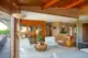 wood accent wall, shaggy carpet and MCM style piano in front room of 1971 Oregon home