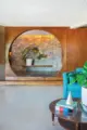 circular entryway framing rock wall and potted houseplant in renovated 1971 home