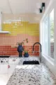 terrazzo counter tops and color block design of backsplash tile in renovated kitchen