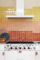 built in stove top and clean lined hood in colorful renovated MCM kitchen