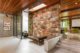 entryway of Dinah Shore Estate with skylight, wooden beam ceiling and rock accent wall