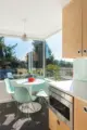 breakfast nook with Saarinen table and mint Eames chairs in sunny corner of 1955 Seattle home renovated kitchen