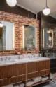 bathroom with brick wall and double sink vanity