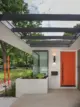 orange front door built-in planter and orange sculptures in exterior entrance of 1950 Kansas home