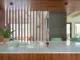 kitchen island with white countertop and mint green stools with view through walnut dividers