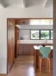 renovated kitchen in 1950 Kansas home with white backsplash tile and walnut cabinetry