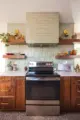 green backsplash tiles terrazzo floor and wood cabinetry in renovated kitchen in Minnesota