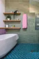 floating shelves above soaking tub and colorful green teal and pink tile in renovated Seattle bathroom