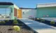 barrel cactus and concrete pavers lead to yellow front door of renovated 1962 Palmer and Krisel home