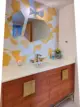 yellow and white hexagonal tile wall in renovated 1962 Palmer and Krisel bathroom