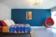 renovated bedroom in 1962 Palmer and Krisel with platform bed, egg chair sputnik chandelier and blue accent wall