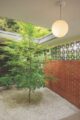 entryway with brick wall roof cutout and Japanese maple and rock garden