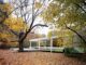 exterior view of the Farnsworth house in Illinois surrounded by fall leaves