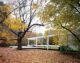 exterior view of the Farnsworth house in Illinois surrounded by fall leaves