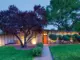 nighttime exterior view of 1957 Denver home with orange front door