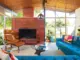 living room with brick fireplace and tan Eames lounge chair